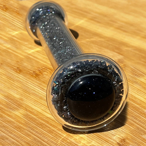 Close up of Goldstone crystal healing stone basix delight dildo base, black with rainbow sparkles.
