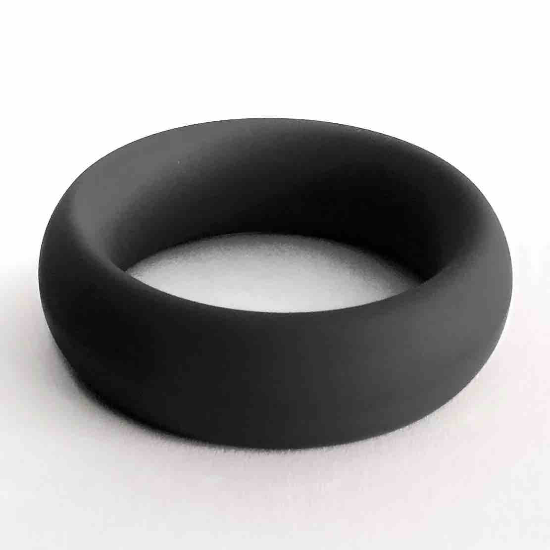 The black Meat Rack Cock Ring lying on its side to show girth.