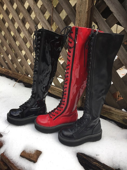 Black patent, red patent, and black matte emily  over-the-knee 2" platform boots in the snow.