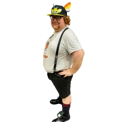 Left side view of classic leather suspenders on model wearing a white mickey mouse t-shirt, leather shorts and Cap with 2 K-Ear Snaps with leather pride K-9 ears and leather boots with red socks.