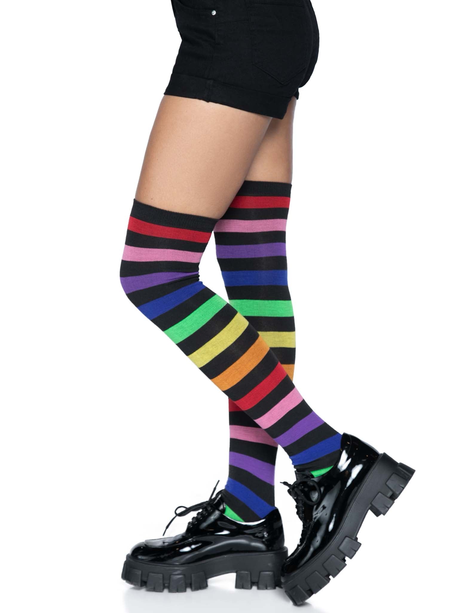 Aurora Rainbow Over The Knee Rainbow Socks on model wearing black shoes and shorts, left side view.