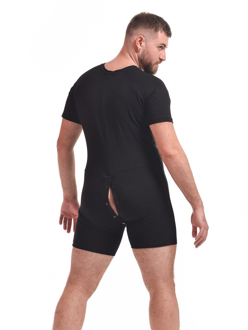 A masculine looking model showing the back of the black Baseball Bamboo Onesie with the behind snaps open.