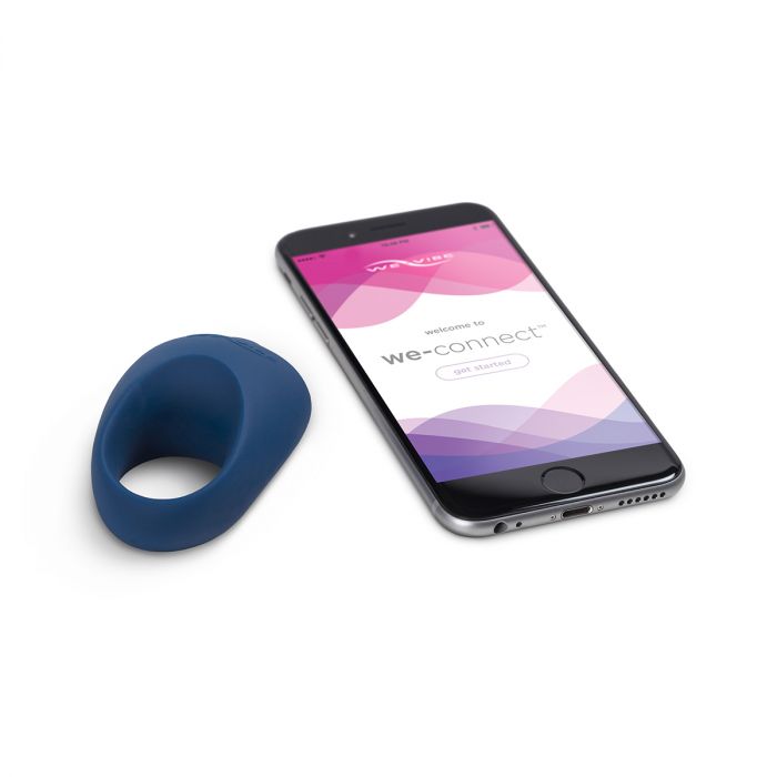 The We-Vibe Pivot Cock Ring Vibrator next to a cellphone displaying the We-Connect app.