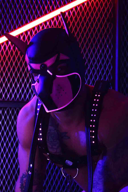A model in a chest harness wears the neon pink Poundtown Glow Pup Hood.