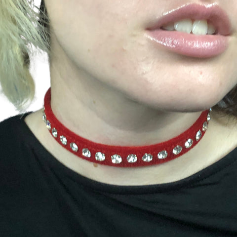 Model wears a red velvet choker with clear rhinestones.