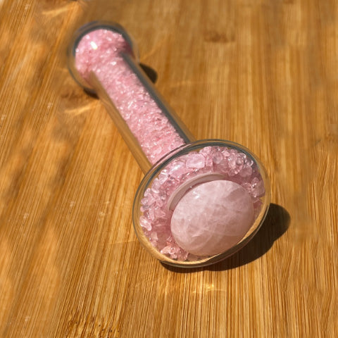Rose quartz healing stone basix delight dildo positioned to show the large quartz stone, on a bamboo board.