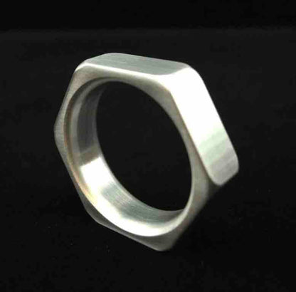 A Aluminum Cock-Nut Cock Ring standing upright.