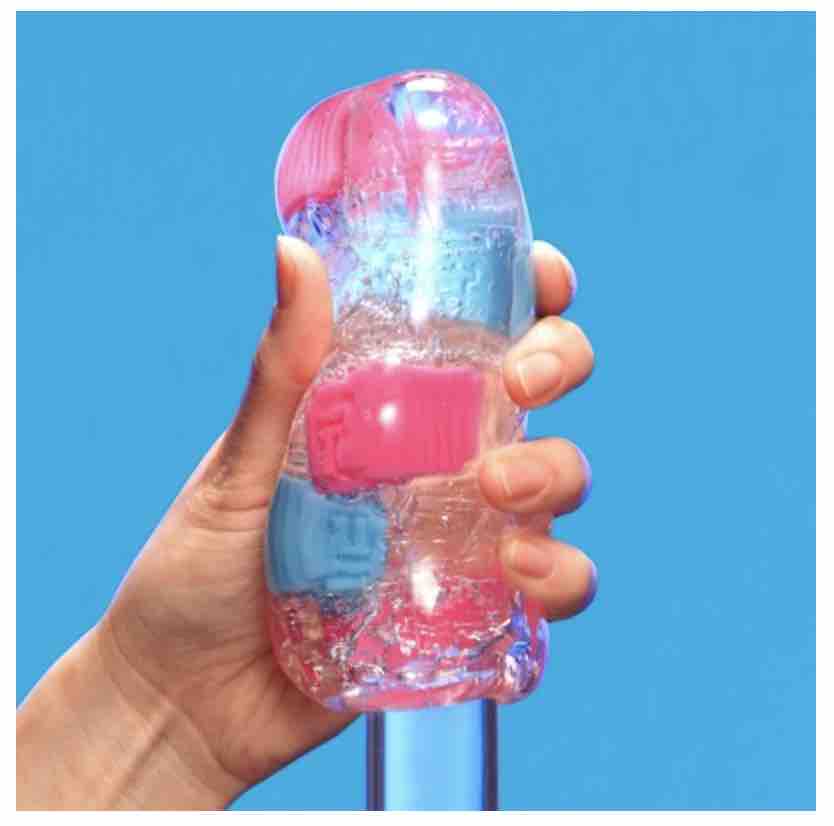 A hand holding the crazy cubes stroker while inserting a clear pole inside to show what insertion looks like.