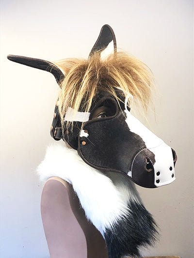 Spotted leather horse mask on a mannequin, right side view.