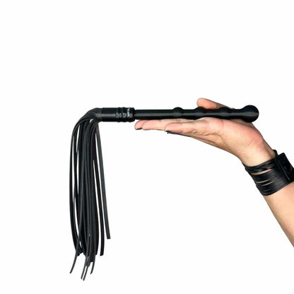 Mini Flogger in handle laying on models hand