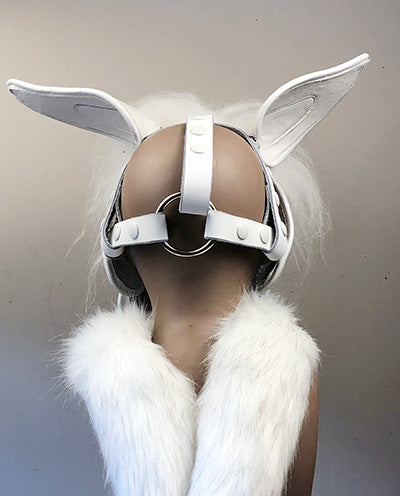 White leather unicorn mask on a mannequin, rear view.