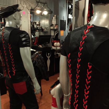 Back view of two mannequins wearing the black cowhide bar vest with red laces.