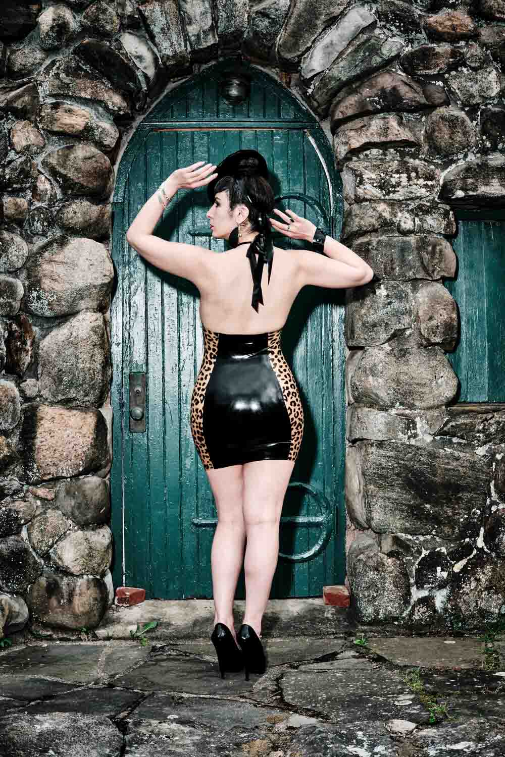 Rear view of the Black and Leopard halter dress on a model.