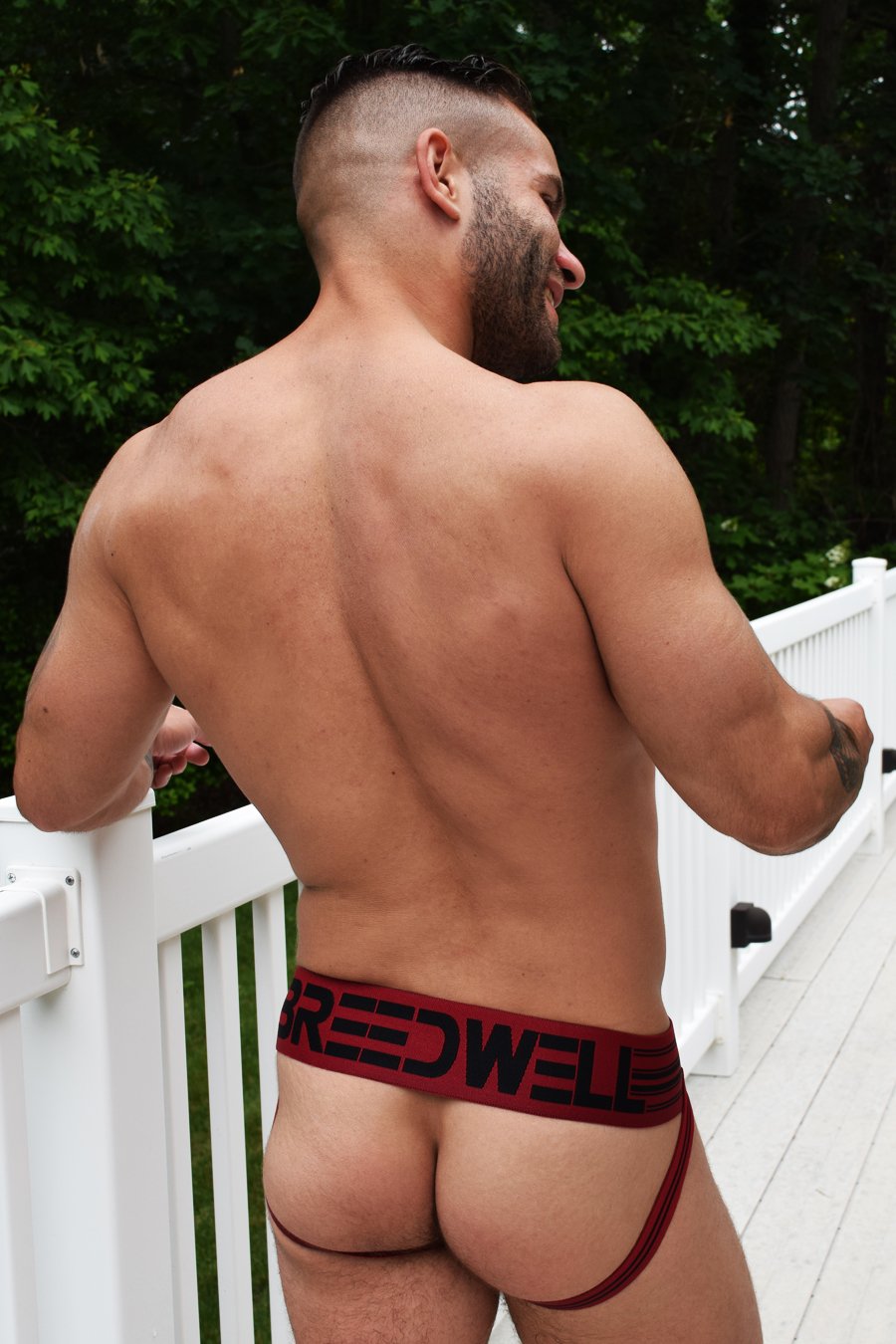 A model displaying the back of the red CumDump Jockstrap.