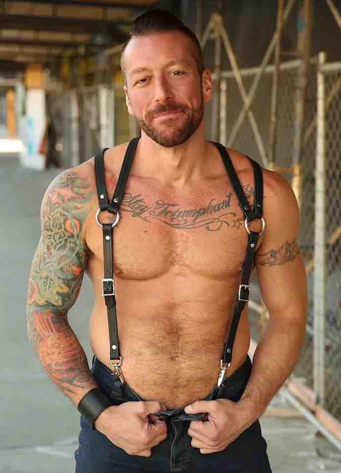 Shirtless model wearing jeans and showing the front of  the Leather Double Strap Suspender Harness.
