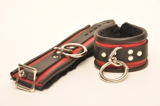 A pair of red and black Rolled Leather Fleece Deluxe Cuffs.
