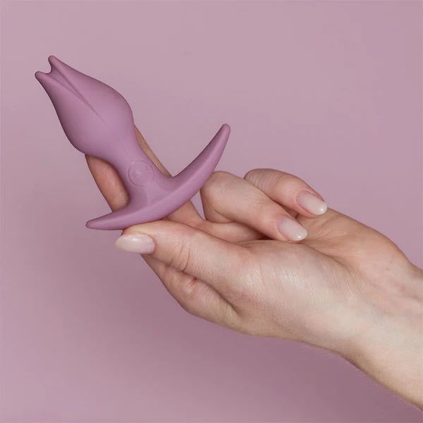 The Bootie Fem Plug in Rose color, side view in model's hand.