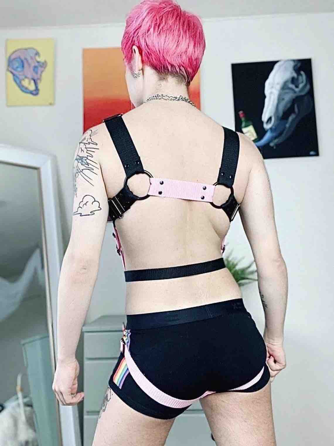 Model showing the back of the Black and Pink Transsexy Full Body Strapping Harness.