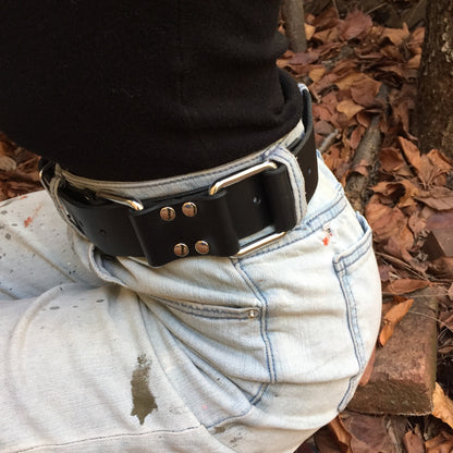 The torso of a girl in a black shirt and light blue jeans, wearing the Restraint Trick Belt on her waist.
