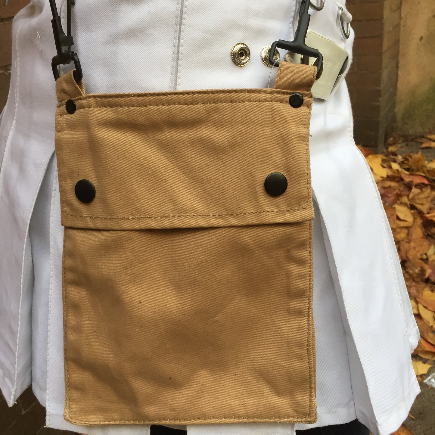 A model wearing the khaki Detachable Pocket for Heritage Kilt hooked to their kilt D-rings.
