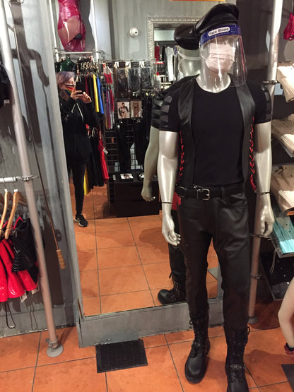 Front view of a mannequin wearing the black cowhide bar vest with red laces matched with leather pants, hat and shoes.