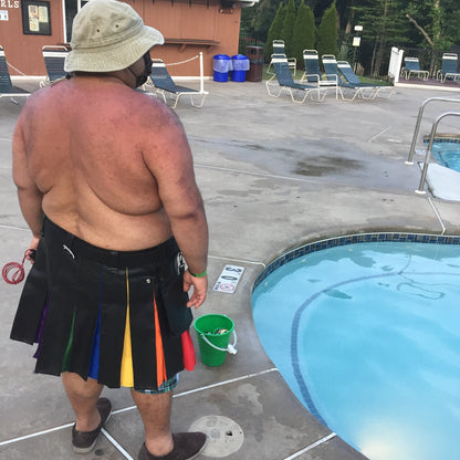 A model standing by the pool showing the back view of vinyl pride kilt.