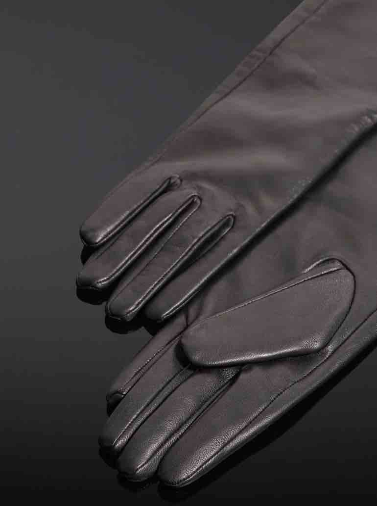 The Leather Forearm Gloves lying flat on a black surface.